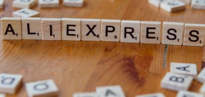 A wooden block spelling the word allexpress on a table